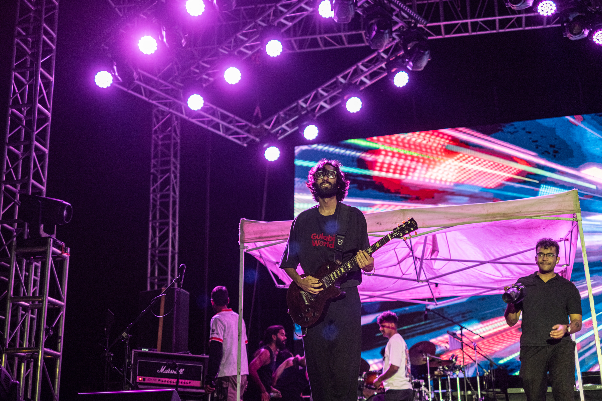 Guitarist framed inside stage light and crowd glow
