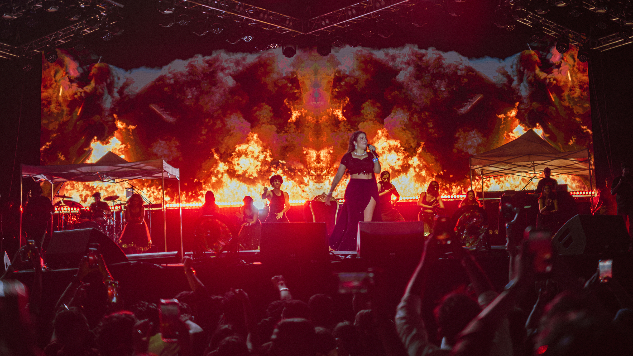 Founder-led production framed against a full-stage fire wall